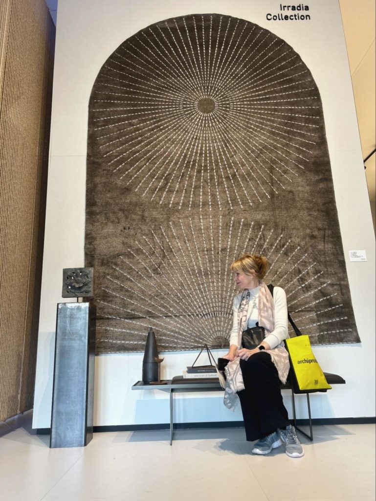 Our founder Margret with one of her decorative wooden tiles at the Golran 1898 stand at Salone Del Mobile Milano 2024.
